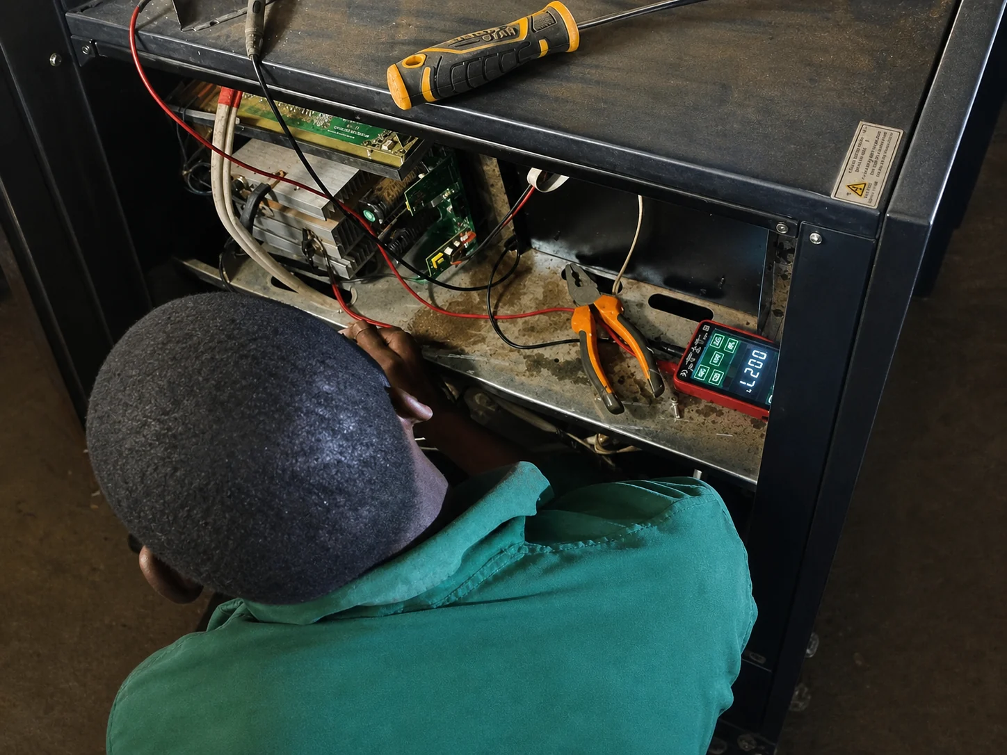 A Smarter Labs technician diagnosing power electronics inside a large inverter cabinet